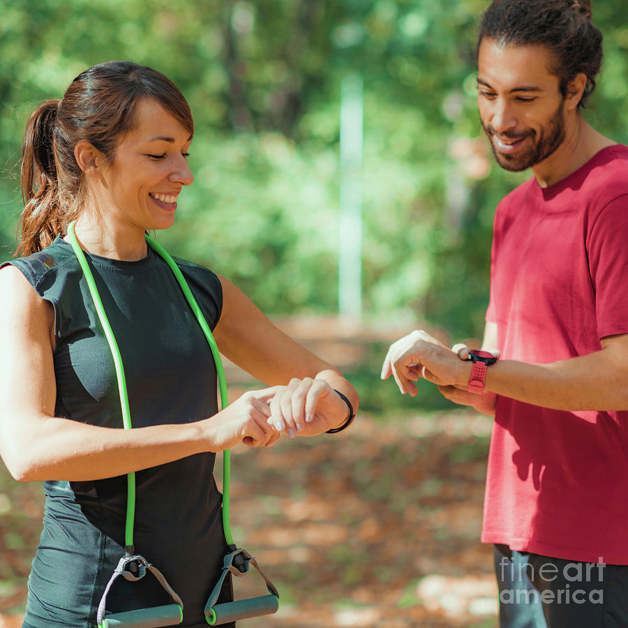 Young Couple Looking At Their Smart Watches After Training #2 Photograph by Microgen Images/science Photo Library
