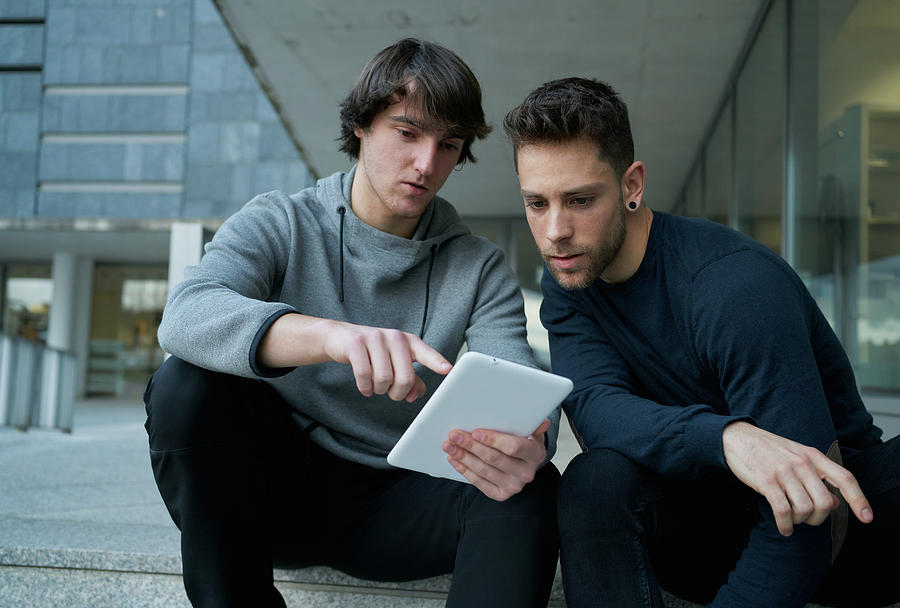 Front View Of Two Young Men Talking Sitting On A City Staircase And Lo ...