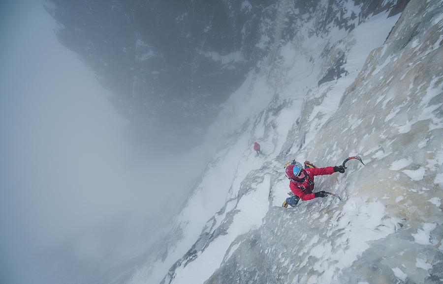 Ice Climber Climbing Steep Ice Wall With Rock Surrounding Him ...