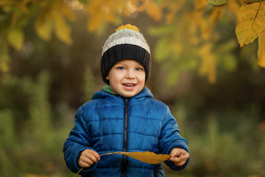 Portrait Of A Small Boy In Garden In Blue Jacket Holding A Yello ...