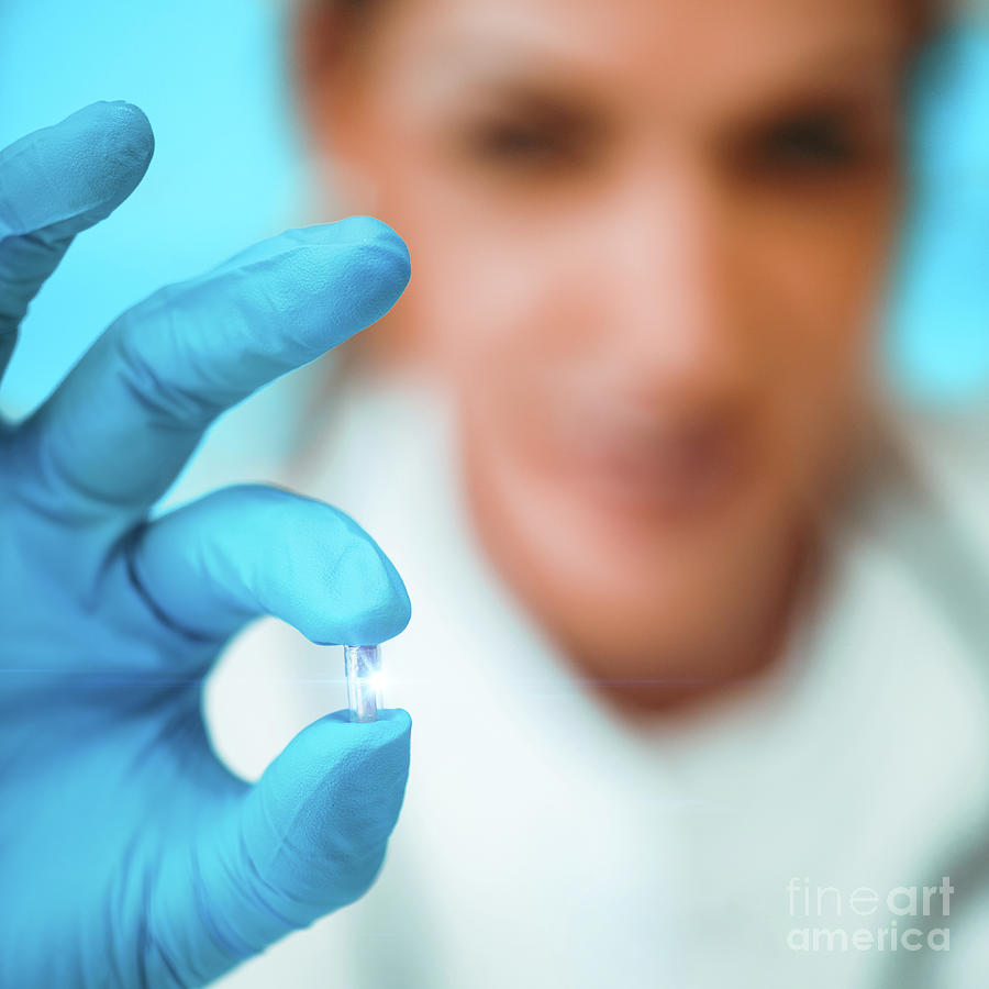 Researcher Holding An Rfid Implant Chip Photograph by Microgen Images