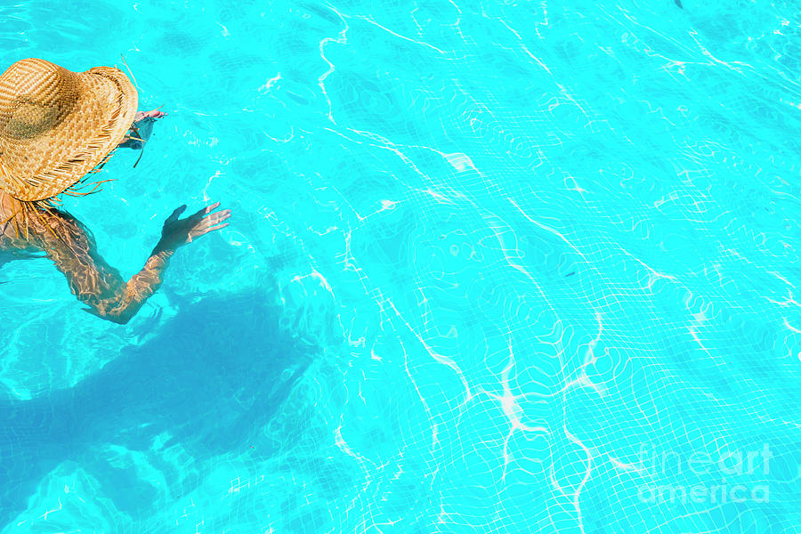 Woman in a pool with hat relaxed and rested. #3 Photograph by Joaquin Corbalan