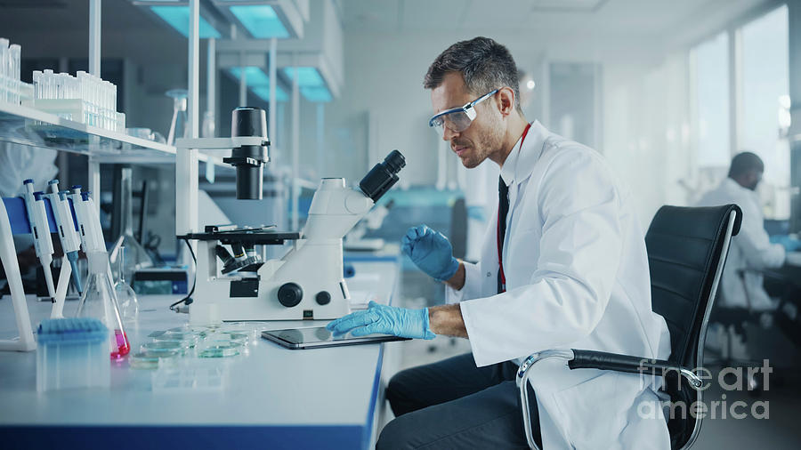 Scientist Using A Microscope Photograph by Gorodenkoff Productions ...