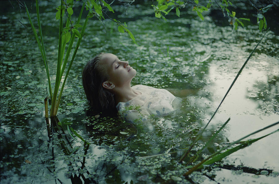 Lily Photograph - A Woman In A White Dress On The Surface Of A Swamp Water In The Forest #4 by Cavan Images