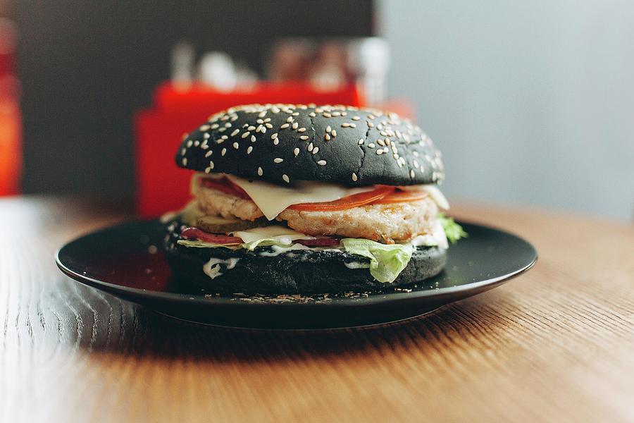 Black Burger With Cheese, Tomatoes And Lettuce #4 Photograph by Kuzmin5d