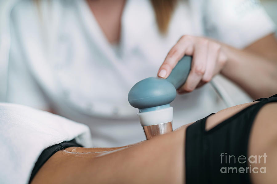 Physiotherapist treating patient for upper back pain with ultrasonic device  Stock Photo by svitlanah