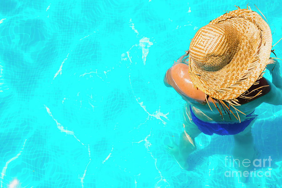 Woman in a pool with hat relaxed and rested. #4 Photograph by Joaquin Corbalan