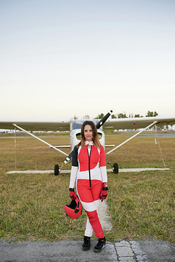 Daredevil Photograph - Young Female Skydiver In An Airfield With A Plane Behind Her #4 by Cavan Images