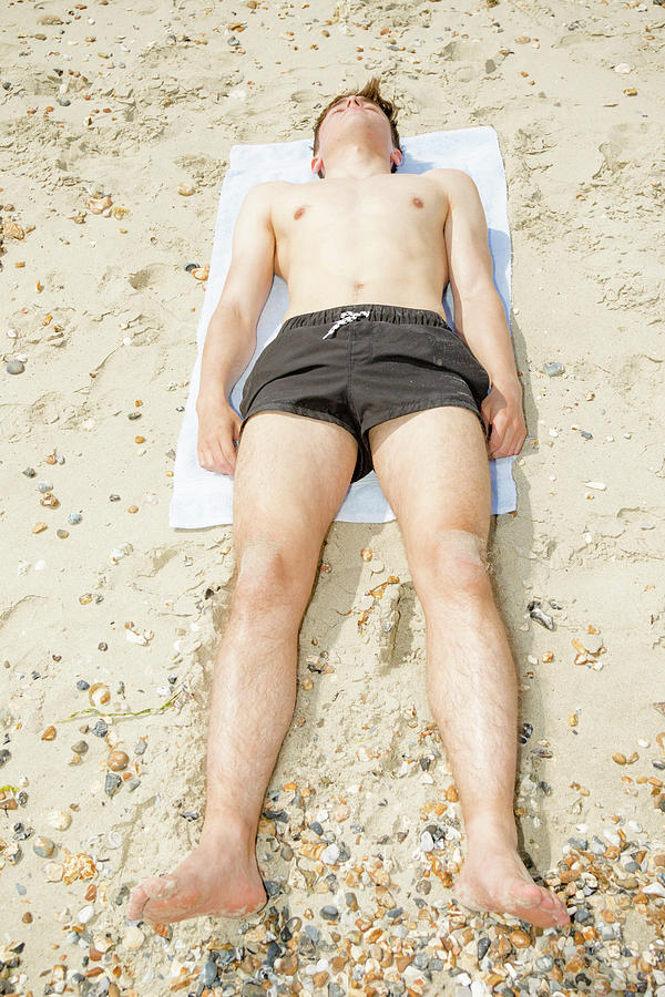 Caucasian male on a beach relaxing by Ben Gingell Caucasian male on a beach relaxing by Ben Gingell