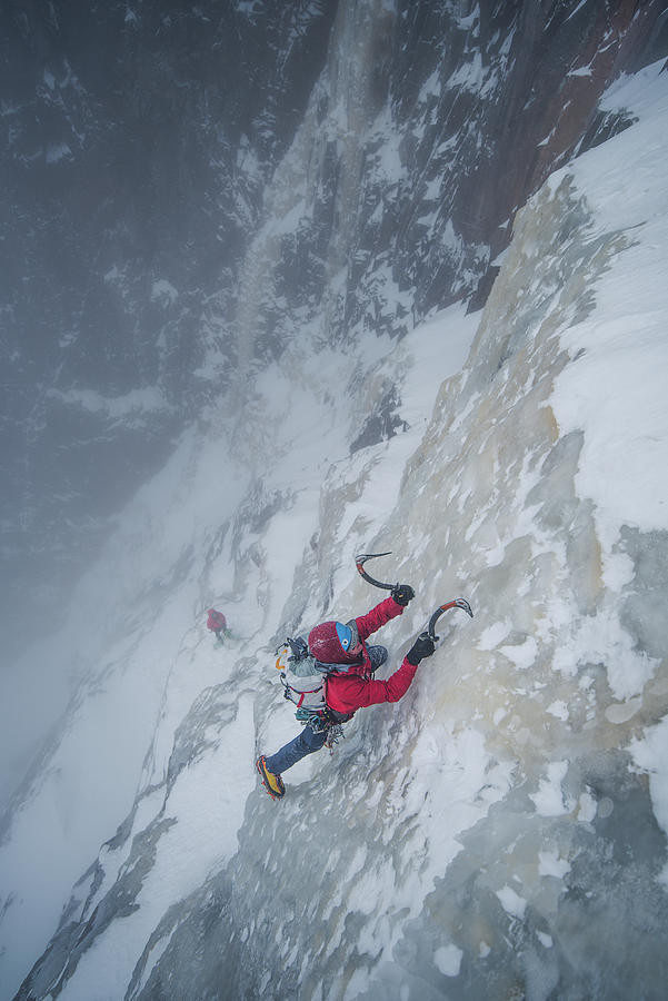 Ice Climber Climbing Steep Ice Wall With Rock Surrounding Him ...