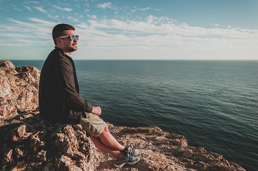 Young Man Looking Out Over Ocean At Sunset In Portugal In Summer ...