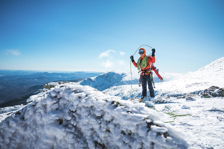 Ski Mountaineer Coiling Rope With Snowy Mountains Behind Photograph by