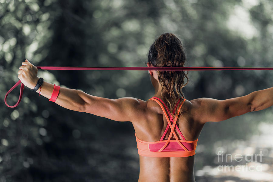 Woman Exercising With Elastic Band Outdoors Photograph By Microgen Images Science Photo Library