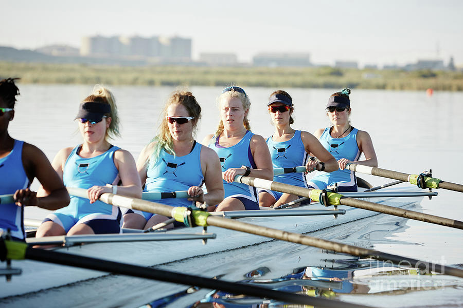Female Rowers Rowing Scull On Sunny Lake Photograph by Caia Image