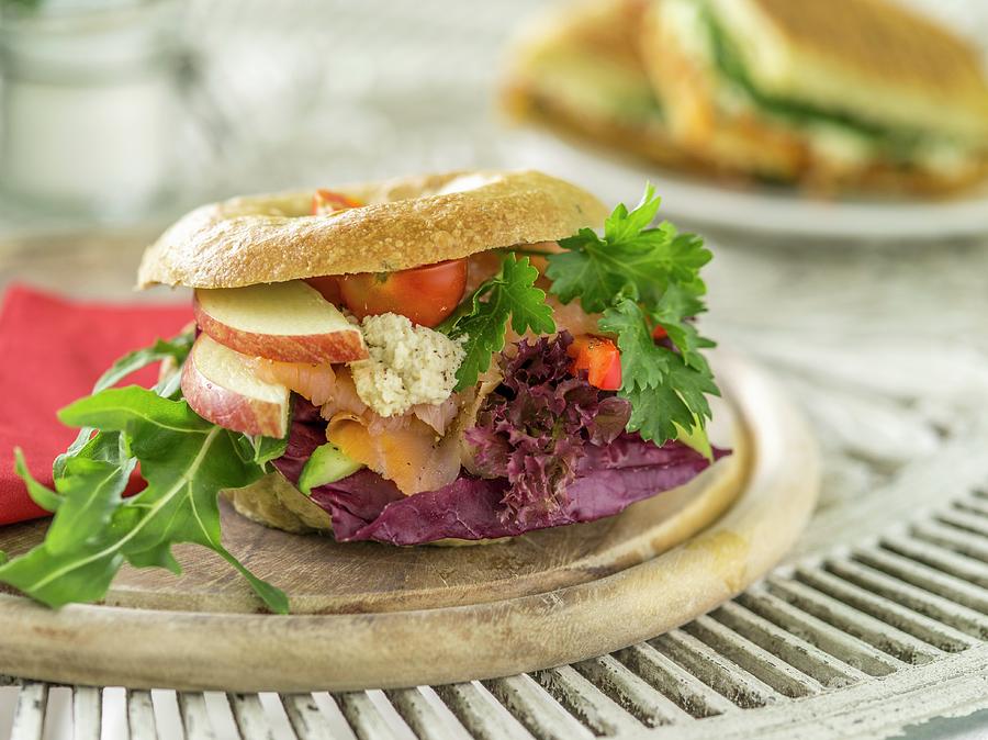 A Bagel With Salmon, Cream Cheese, Lettuce, Apples And Tomatoes Photograph by Manuel Krug