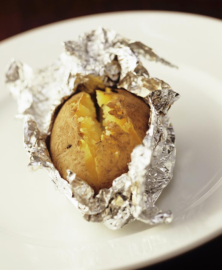 A Baked Potato In Aluminium Foil Photograph By Michael Wissing - Pixels