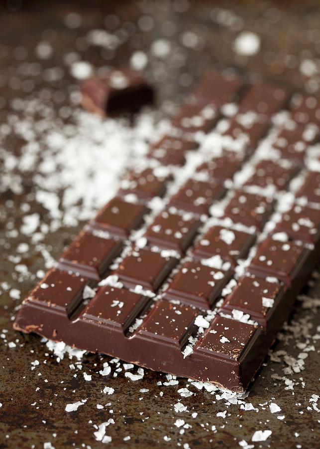 A Bar Of Dark Chocolate Sprinkled With Sea Salt Flakes Photograph by Jane Saunders