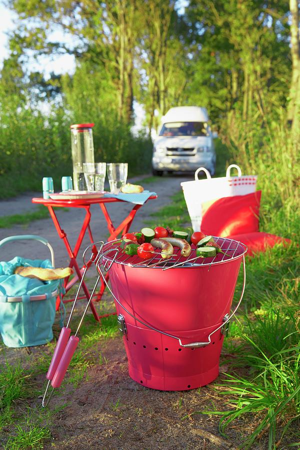 A Barbecue, A Camping Table And A Basket On The Edge Of A Road Photograph by Jalag / Olaf Szczepaniak