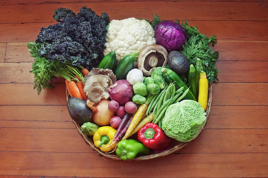 A Basket Of Vegetables On A Wooden Surface Photograph by Kelsey Skiver