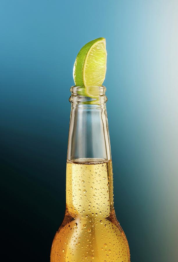 A Beer Bottle With Condensation And A Lime Wedge Photograph by Julian Winkhaus