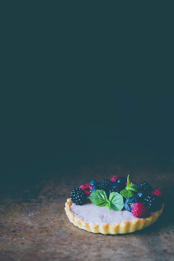 A Berry Cake With Mint Against A Dark Surface Photograph by Malgorzata Laniak