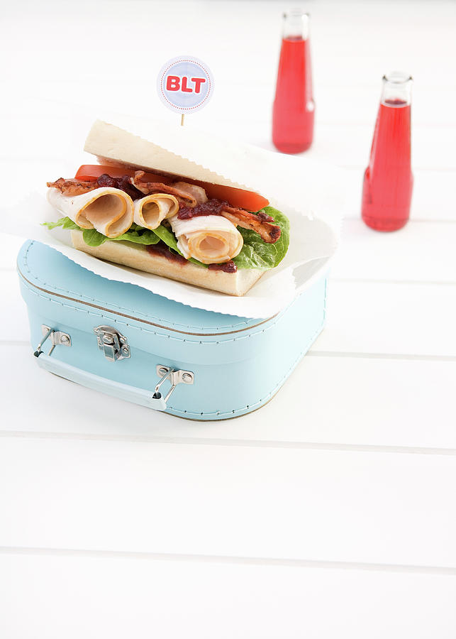 A Blt Sandwich With Sliced Turkey Breast On A Vintage Suitcase Photograph by Trudy Kelder