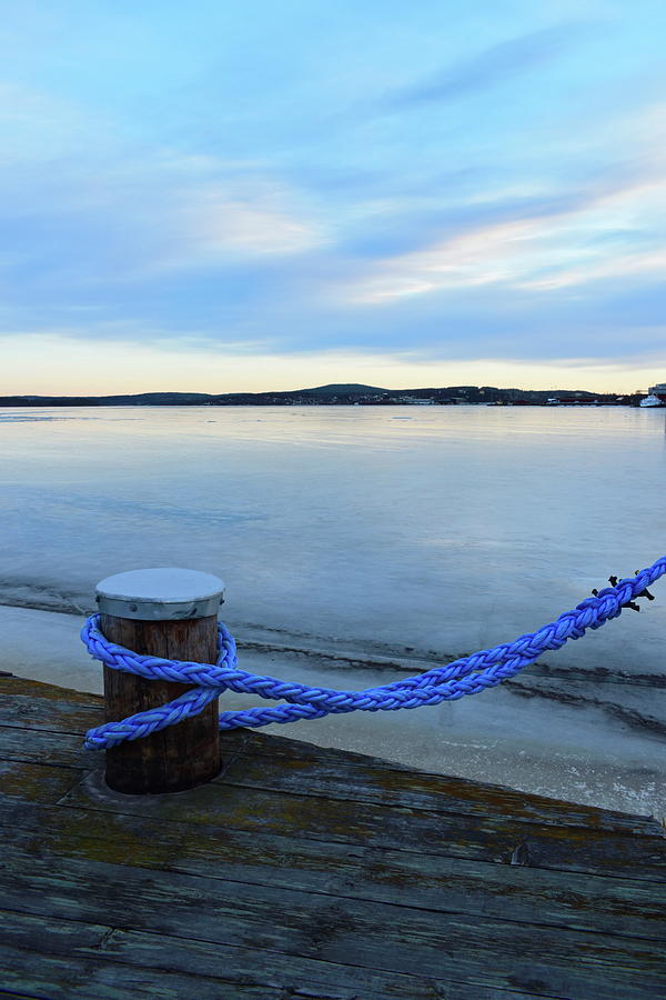 A blue rope secures a ship to a bollard in an icy harbor Photograph by Intensivelight