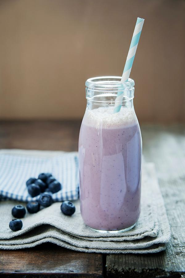 A Blueberry And Banana Smoothie In A Bottle With A Straw Photograph by Victoria Firmston