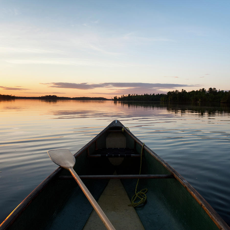 A Boat And Paddle On A Tranquil Lake At Photograph by Keith Levit / Design Pics
