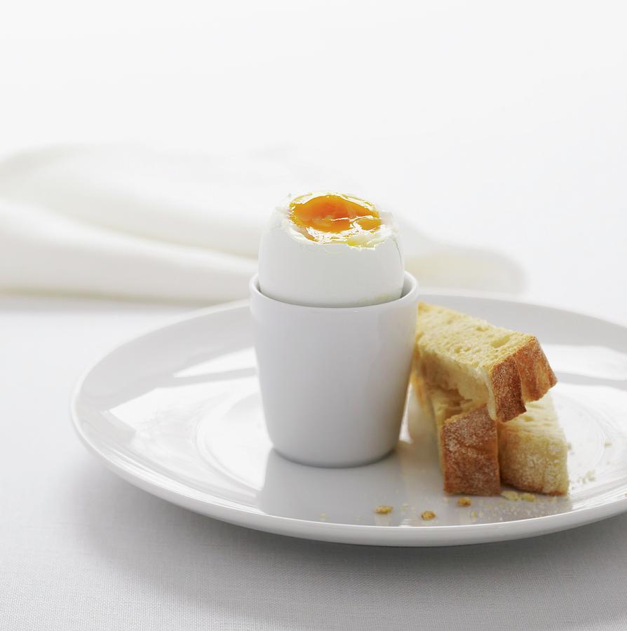 A Boiled Egg In A White Egg-cup With Three Fingers Of Lightly Toasted Bread Photograph by Will Shaddock Photography