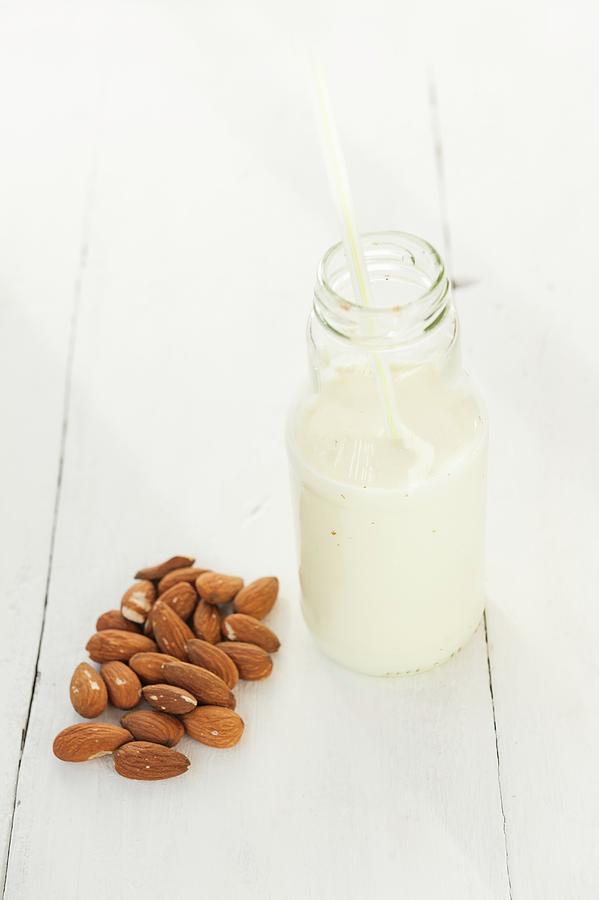 A Bottle Of Almond Milk And Almonds Photograph by Gabriela Lupu