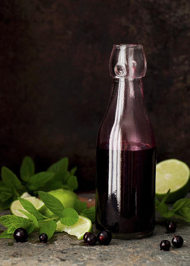 A Bottle Of Blackcurrant Syrup With Lime And Mint Photograph by Jane Saunders