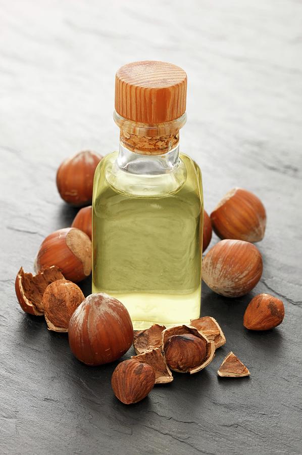 A Bottle Of Hazelnut Oil Surrounded By Hazelnuts Photograph by Petr Gross
