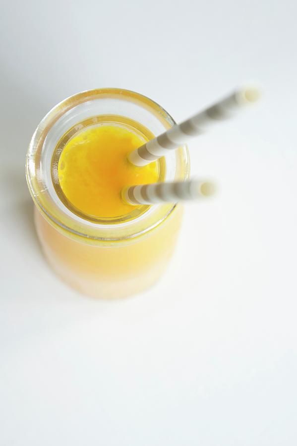 A Bottle Of Orange Juice With Straws Photograph by Martina Schindler