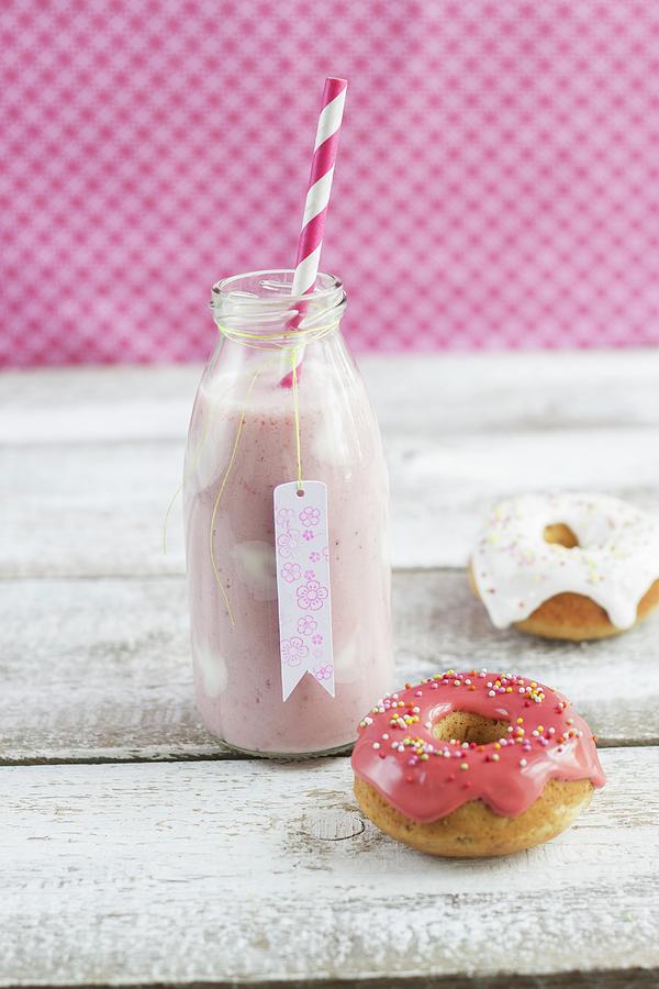 A Bottle Of Strawberry Milk With Yoghurt Spots And Mini Iced Doughnuts Photograph by Tina Engel