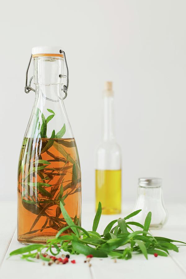 A Bottle Of Tarragon Vinegar, Fresh Tarragon And Peppercorns Photograph by Jane Saunders