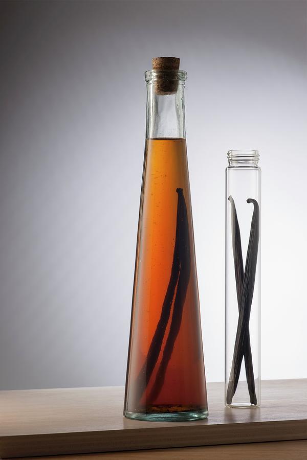 A Bottle Of Vanilla Extract And Two Vanilla Pods In A Glass Tube Photograph by Laurange