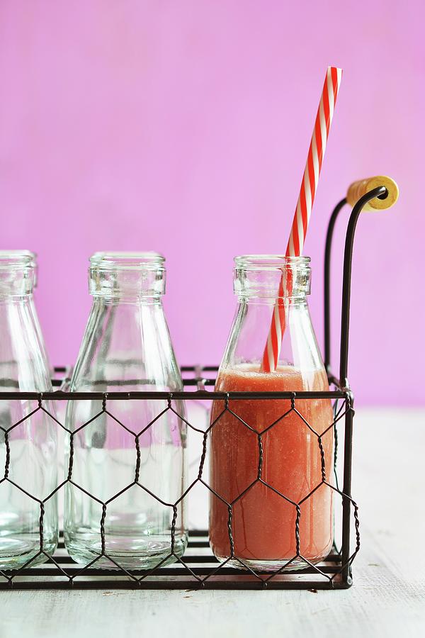 A Bottle Of Watermelon Smoothie With A Straw In A Wire Basket Photograph by Mariola Streim