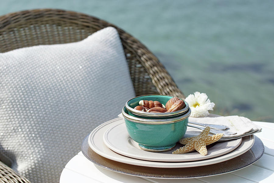 A Bowl Of Chocolates At A Place Setting With A Starfish On A Table On The Beach Photograph by Angelica Linnhoff