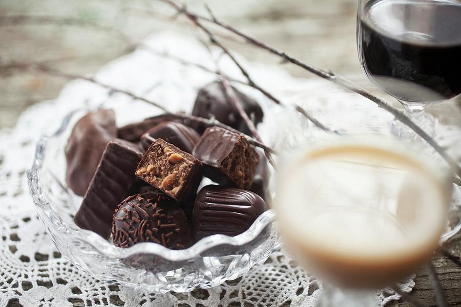 A Bowl Of Filled Chocolates With A Glass Of Baileys And One Of Kahlua Photograph by Stepien, Malgorzata