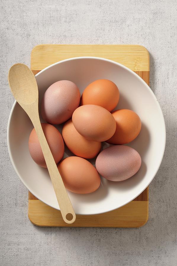 A Bowl Of Fresh Eggs With A Wooden Spoon Photograph by Jean-christophe Riou