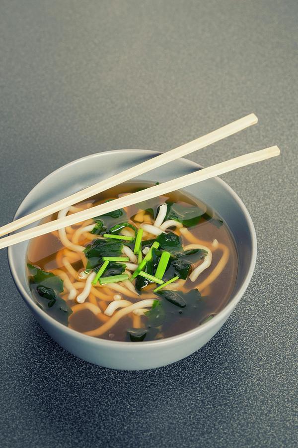 A Bowl Of Japanese Udon Noodle Soup, Algae, Chives And Chopsticks Photograph by Jan Wischnewski