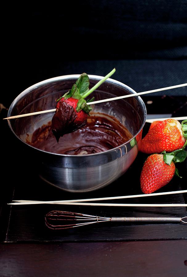 A Bowl Of Melted Chocolate With Strawberries For Dipping; A Chocolate Covered Strawberry In The Bowl Photograph by Strokin, Yelena