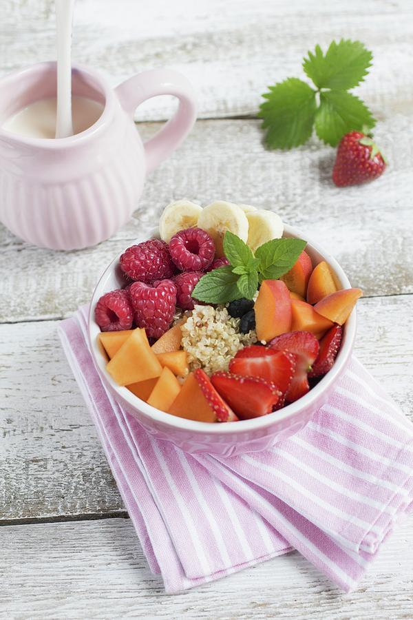 A Bowl Of Quinoa, Fresh Fruit And Mint Leaves, A Jug Of Milk And A Strawberry With A Leaf Photograph by Tina Engel