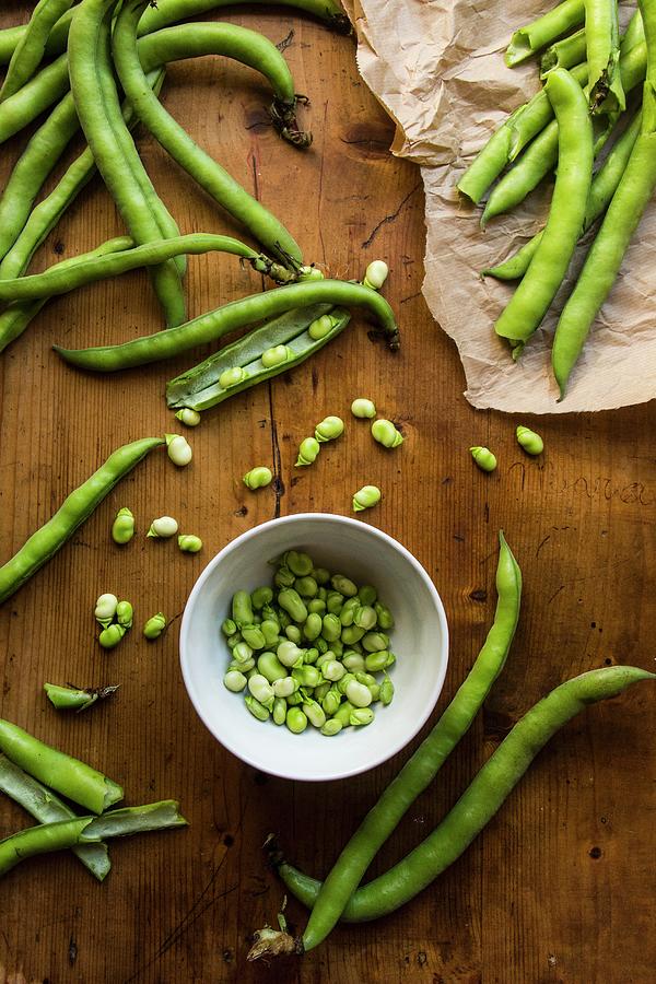 A Bowl Of Shelled Broad Beans Surrounded By Beans In Pods Photograph by Alice Del Re