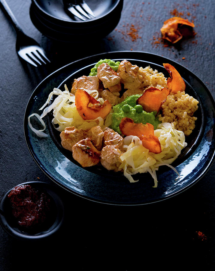 A Bowl With Tandoori Chicken, Mushy Peas, White Cabbage And Sweet Potato Crisps Photograph by Udo Einenkel