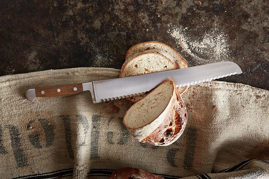 A Bread Knife And A Loaf Of Bread Photograph by Thorsten Kleine Holthaus