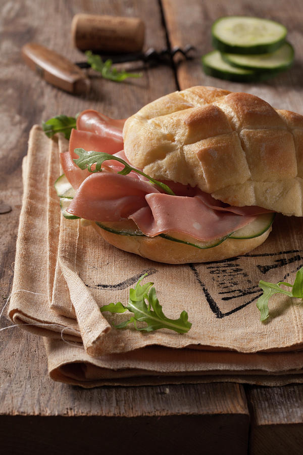A Bread Roll With Mortadella, Cucumber And Rocket Photograph by Blueberrystudio