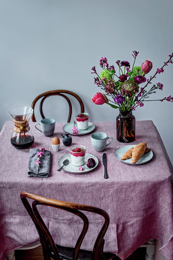 A Breakfast Table Laid With Coffee, Coconut Milk Yoghurt, Raspberries, An Egg, Spelt Croissants And A Flower Bouquet Photograph by Carolin Strothe