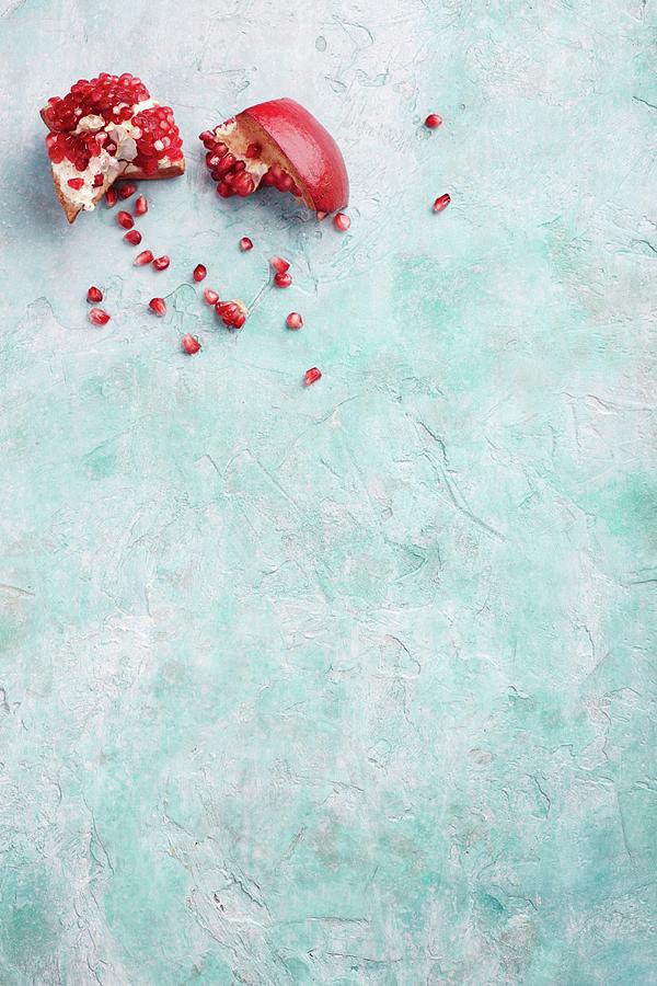 A Broken Pomegranate On A Blue Surface Photograph by Tim Atkins Photography